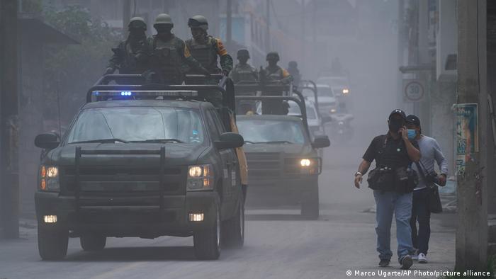 Члены мексиканской национальной гвардии идут по улицам, покрытым пеплом от вулкана Попокатепетль, в Сантьяго-Халицинтла, Мексика, понедельник, 22 мая 2023 года. 