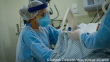 Eine medizinische Mitarbeiterin behandelt einen Patienten im öffentliche Krankenhaus Parelheiros. Die Zahl der Corona-Toten in Brasilien liegt bei über 50 000. +++ dpa-Bildfunk +++