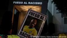 23.05.2023, Brasilien, Sao Paulo: Demonstranten von antirassistischen sozialen Bewegungen versammeln sich vor dem spanischen Generalkonsulat und halten ein Portrait von Vinicius Junior, um gegen die rassistischen Angriffe auf den brasilianischen Spieler von Real Madrid zu protestieren. Foto: Allison Sales/dpa +++ dpa-Bildfunk +++