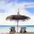 Zwei Strandstühle und ein Sonnenschirm stehen am Strand mit Blick aufs Meer