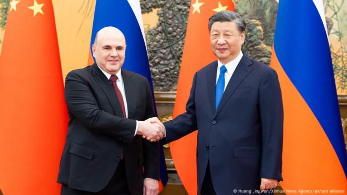 El presidente chino, Xi Jinping (der.), junto al primer ministro ruso, Mijail Mishustin.