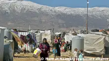 30.01.2019, Libanon, Mardsch: Syrische Flüchtlinge gehen durch ein Flüchtlingslager in der Bekaa-Ebene. Im Libanon leben rund 1,5 Millionen Syrer. Die libanesische Regierung hat die Weltmächte aufgefordert, sich stärker um die Rückkehr syrischer Flüchtlinge zu bemühen. Foto: Marwan Naamani/dpa +++ dpa-Bildfunk +++
