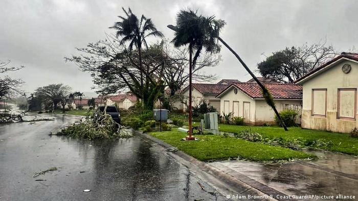 En esta foto facilitada por la Guardia Costera de EE.UU., ramas de árboles caídas ensucian un barrio de Yona, Guam, el jueves 25 de mayo de 2023, tras el paso del poderoso tifón Mawar por esta isla del Pacífico con fuertes vientos y lluvias torrenciales.