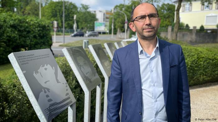 Rasim Cetin steht 30 Jahre nach dem Brandanschlag in Solingen vor Tafeln mit Bildern der Opfer. 