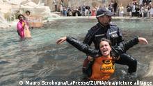 Klimaaktivisten der «Letzten Generation» werden von Polizisten aus dem Wasser des Trevi-Brunnen geleitet. +++ dpa-Bildfunk +++