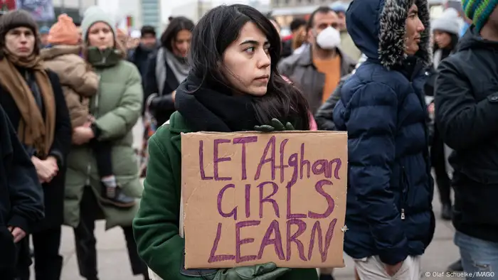 Woman holding up sign at demonstration in Berlin