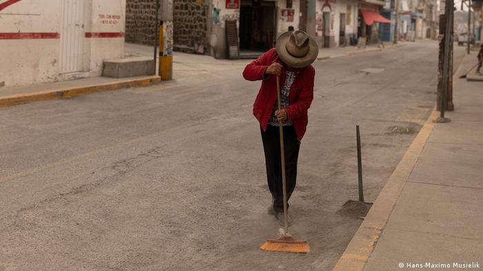 Una mujer barre la acera en San Nicolás de los Ranchos, cerca del volcán Popocatépetl en México. Una mujer barre la acera en San Nicolás de los Ranchos, cerca del volcán Popocatépetl en México.