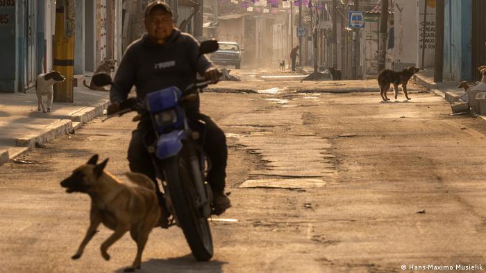 Un motociclista y un perro que corre en una calle de San Nicolás de los Ranchos, cerca del volcán Popocatépetl, en México. Un motociclista y un perro que corre en una calle de San Nicolás de los Ranchos, cerca del volcán Popocatépetl, en México.