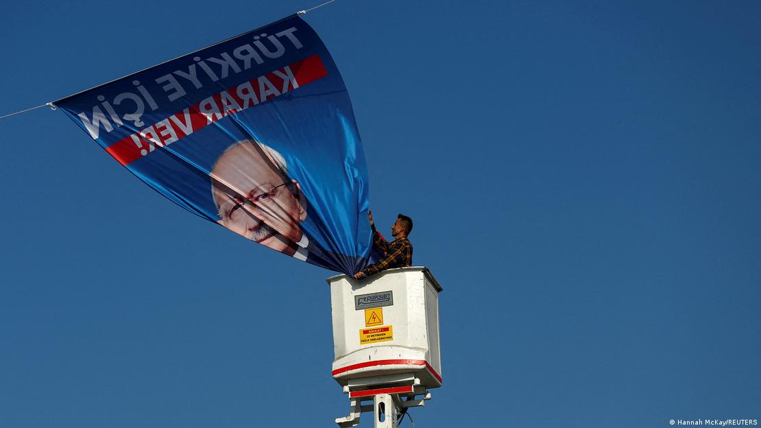 Një mbështetës i presidentit Erdogan duke hequr një pllakatë elektorale të Kilicdaroglut