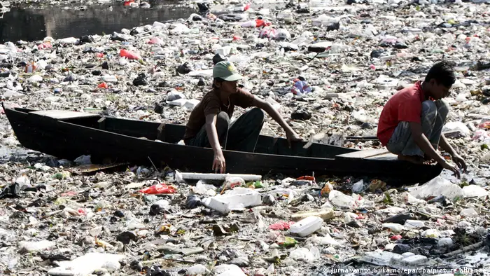 印尼小男孩在雅加达一个被污染的河床中收集塑料瓶