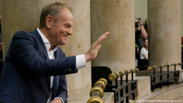 Der Oppositionspolitiker Donald Tusk winkt im Warschauer Parlament von einer Brüstung (26.05.2023)