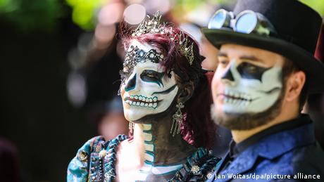 Zwei Kostümierte beim Wave-Gotik-Treffen, deren Gesichter wie Totenköpfe geschminkt sind.