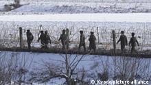 Photo taken on Dec. 22, 2022, from China's Dandong shows North Korean soldiers patrolling on a riverside in the border county of Uiju. (Kyodo)