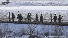 Photo taken on Dec. 22, 2022, from China's Dandong shows North Korean soldiers patrolling on a riverside in the border county of Uiju. (Kyodo)