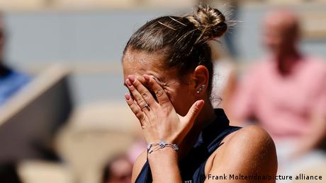 Die ukrainische Tennisspielerin Marta Kostyuk wischt mit der linken Hand die Tränen aus dem Gesicht