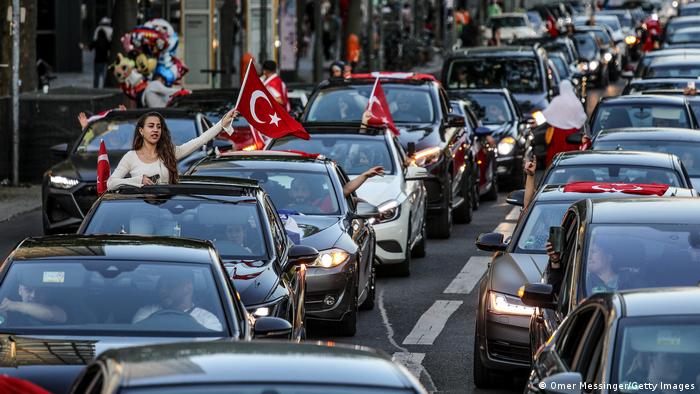 Erdogans Anhänger haben in Berlin mit Autokorsos gefeiert. Auf dem Foto sieht man mehrere Autos und Menschen mit Türkei-Flaggen. 