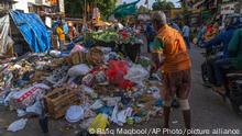 A man throws plastic and other garbage on a roadside in Mumbai, India, Monday, May 29, 2023. A United Nations committee met in Paris Monday to work on what is intended to be a landmark treaty to bring an end to global plastic pollution, but there is little agreement yet on what the outcome should be. (AP Photo/Rafiq Maqbool)