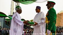 In this photo released by the Nigeria State House, Nigeria's new President Bola Ahmed Tinubu, left, receives Nigeria flags from former Nigerian President Muhammadu Buhari, during the inauguration ceremony in Abuja, Monday, May 29, 2023. Tinubu has been sworn in as president of Africa's most populous country at a period of unprecedented challenges, leaving some citizens hopeful for a better life and others skeptical that his government would perform better than the one he succeeded. (Sunday Aghaeze/Nigeria State House via AP)