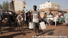 People gather to collect water in Khartoum, Sudan, Sunday, May 28, 2023. The Sudanese army and a rival paramilitary force, battling for control of Sudan since mid-April, had agreed last week to the weeklong truce, brokered by the U.S. and the Saudis. However, the cease-fire, like others before it, did not stop the fighting in the capital of Khartoum and elsewhere in the country. (AP Photo/Marwan Ali)