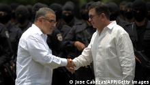 The President of El Salvador Mauricio Funes (L) shakes hands with the National Public Security Minister Gral. David Munguia Payes at the end of a graduation ceremony of 302 members of the anti-gang unit of the National Civil Police of El Salvador at the National Police Academy in Comalapa, 44 kms south from San Salvador, El Salvador on April 19, 2012. AFP PHOTO/ Jose CABEZAS (Photo credit should read Jose CABEZAS/AFP via Getty Images)