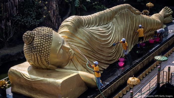 Arbeiter reinigen eine Buddha-Statue im indonesischen Mojokerto vor dem großen Visakha-Puja-Fest