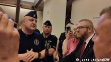 Police officers talk to radical right-wing MP Grzegorz Braun (right) at an event at the German Historical Institute, Warsaw, Tuesday, May 30, 2023