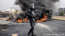 29.05.2023 *** TOPSHOT - A Senegalese gendarme stand near a smoke billowing from burning tyres during a protest in Dakar on May 29, 2023, over the arrest of opposition leader Ousmane Sonko ahead of the final verdict in his rape trial. Sonko, who has a significant youth following, is facing a rape trial which could result in him being ineligible to run in next year's presidential election. (Photo by JOHN WESSELS / AFP)