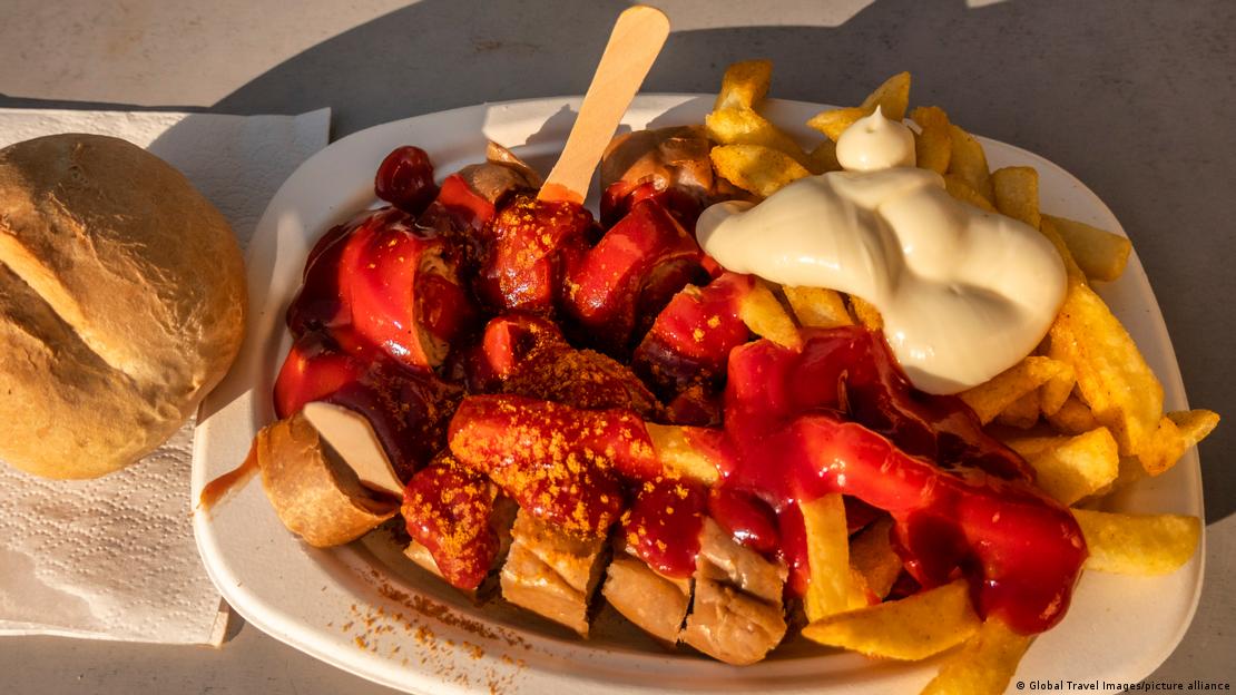 Prato de linguiça alemã com batatas fritas ao molho de tomate e curry Prato de linguiça alemã com batatas fritas ao molho de tomate e curry