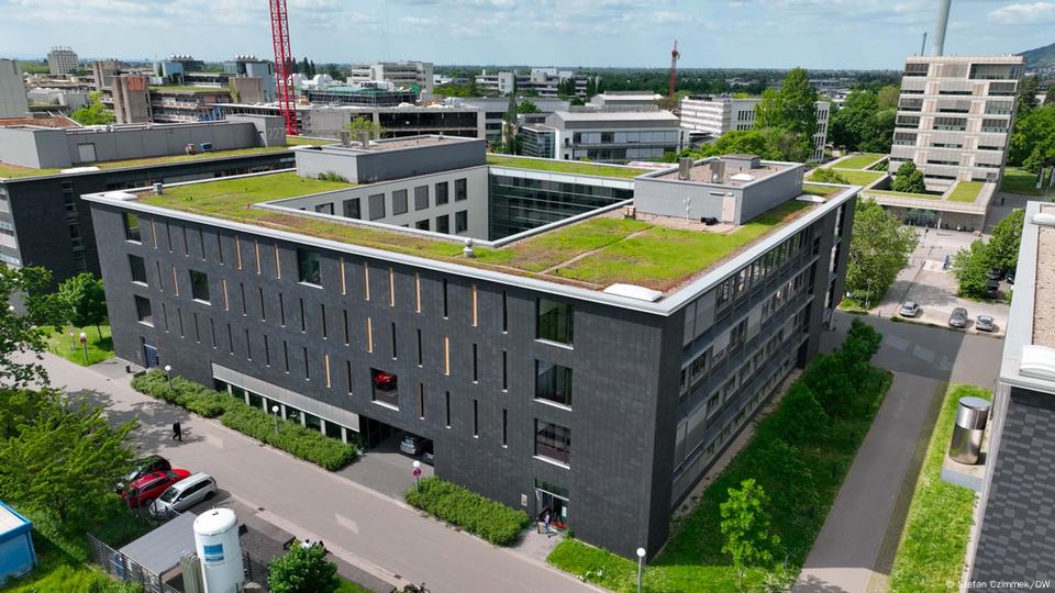 An aerial image of Heidelberg University's Institute of Phsics, a a grey , square building with grass growing on its roof. An aerial image of Heidelberg University's Institute of Phsics, a a grey , square building with grass growing on its roof.