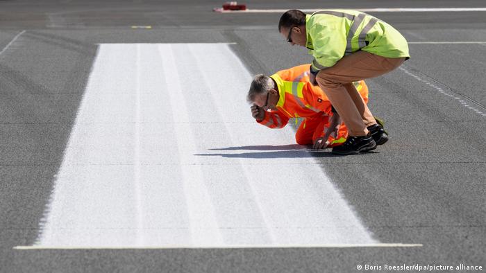 Arbeiter kontrollieren die sanierte Nordwest-Landebahn am Frankfurter Flughafen