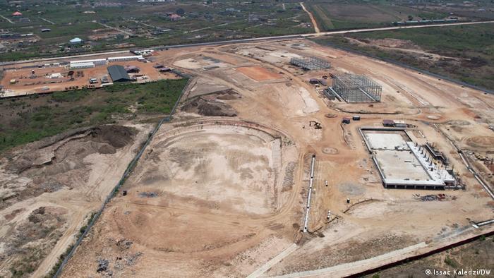 Die Baustelle des Borteyman Sportkomplexes am Rande von Ghanas Hauptstadt Accra. Zu sehen sind rudimentäre Bodenarbeiten und zwei Hallen im Rohbau. Hier soll unter anderem ein Schwimmbad für die Schwimmwettkämpfe entstehen. 