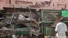 Una casa con impactos de balas en Jartum, delante unos puestos de tienda destrozados.