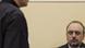 Man (l.) standing reading charges in the UN court in the Hague. Goran Hadzic (r.) is sitting Man (l.) standing reading charges in the UN court in the Hague. Goran Hadzic (r.) is sitting