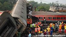 TOPSHOT - Rescue workers gather around damaged carriages at the accident site of a three-train collision near Balasore, about 200 km (125 miles) from the state capital Bhubaneswar in the eastern state of Odisha, on June 3, 2023. At least 288 people were killed and more than 850 injured in a horrific three-train collision in India, officials said on June 3, the country's deadliest rail accident in more than 20 years. (Photo by DIBYANGSHU SARKAR / AFP)