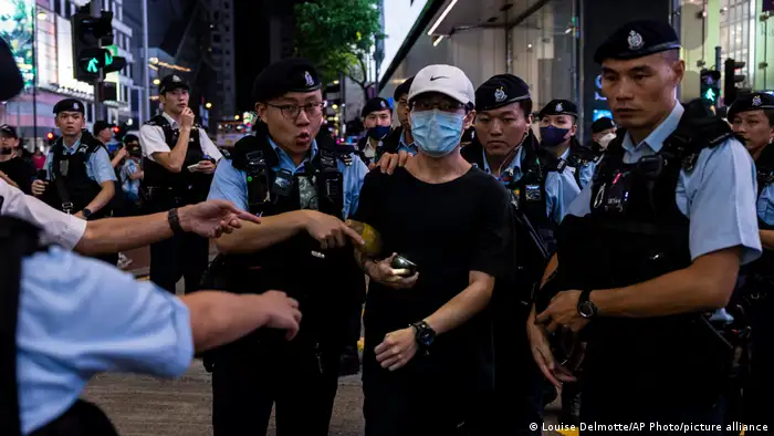 多名员警将一名开着手机闪光灯的男子带离维园附近。香港警方晚上表示，6月4日当天有11男12女，合共23人涉嫌「破坏社会安宁」被警方拘捕或带走调查；有1人因「涉嫌妨碍警务人员执行职务」遭到拘捕。