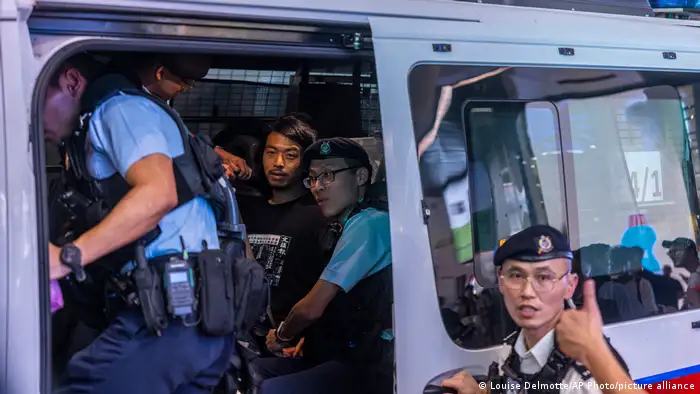 香港職工盟前副主席鄧建華，身穿印有《文匯報》六四報導的黑色上衣，他在維園附近遭警方帶走。