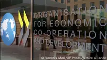 FILE - The logo at the entrance of the Organisation for Economic Co-operation and Development (OECD) headquarters in Paris, June 7, 2017. The OECD on Monday, Sept. 26, 2022 says Russia’s war in Ukraine and the lingering effects of the COVID-19 pandemic are dragging down global economic growth more than expected and driving up inflation that will stay high into next year. The Paris-based organization projects worldwide growth to be a modest 3% this year before slowing further to just 2.2% next year, representing around $2.8 trillion in lost global output in 2023. (AP Photo/Francois Mori, file)