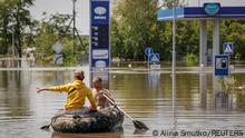 07.06.23 Local residents sail on a boat at a street during an evacuation from a flooded area after the Nova Kakhovka dam breached, amid Russia's attack on Ukraine, in Kherson, Ukraine June 7, 2023. REUTERS/Alina Smutko