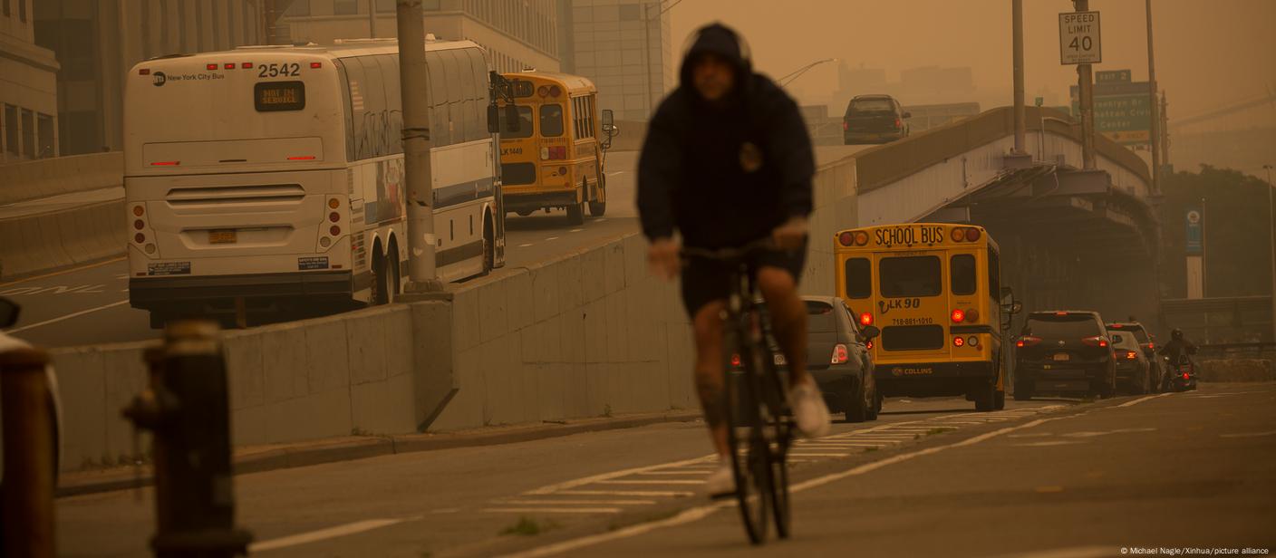 A display board that says 'Air Quality Alert Day' seen at the entrance of a highway, amidst an orange hue