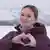 Lilia Chanysheva forming a heart symbol with her hands