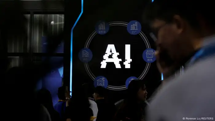 Visitors stand near a sign of artificial intelligence at a trade fair