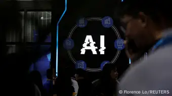 People stand near a sign with letters AI