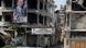 A man walks past banners depicting Syria's President Bashar al-Assad, near damaged buildings A man walks past banners depicting Syria's President Bashar al-Assad, near damaged buildings