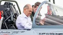 German Chancellor Olaf Scholz (L) sits in the cockpit of an Eurofighter aircraft of the German Armed Forces Luftwaffe next to a German Armed Forces (Bundeswehr) soldier at the military air base in Jagel, southern Germany, during the Air Defender Exercise 2023 on June 16, 2023. The Air Defender 2023 is a multinational air operation exercise including some 220 military aircraft from 25 NATO and partner countries in European airspace under the command of the German Air Force taking place from June 12 to June 24, 2023. The exercise will include operational and tactical-level training, primarily in Germany, but also in the Czech Republic, Estonia and Latvia. (Photo by Axel Heimken / AFP) (Photo by AXEL HEIMKEN/AFP via Getty Images)