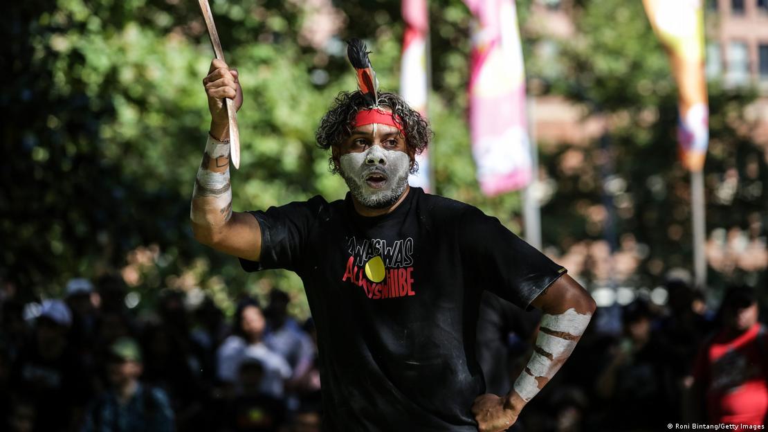 Homem negro e aborígene faz performance crítica ao feriado nacional australiano, que os indígenas chamam de "Dia da Invasão".