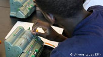 Ein Schüler rechnet mit einer mechanischen Maschine im Mathe-Museum (Foto: Universität zu Köln)