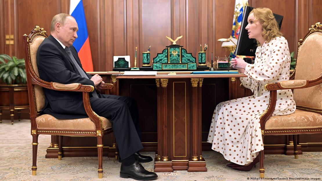 Wladimir Putin und Maria Lwowa-Belowa sitzen einander gegenüber an einem Tisch im Kreml