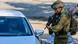 Un militar israelí inspecciona un vehículo ante la mirada de su conductor en un control de carretera. Un militar israelí inspecciona un vehículo ante la mirada de su conductor en un control de carretera.