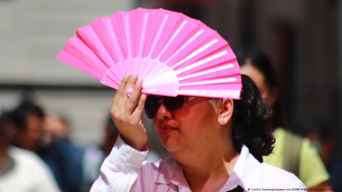 Una mujer se cubre del Sol con un abanico en Ciudad de México