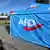 AfD-Mitglieder sitzen auf einem Landesparteitag der AfD Sachsen-Anhalt in einem Zelt. 